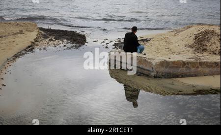 Palma, Spanien. 11. Mai 2023. Ein Mann schaut auf das Meer am Strand von Arenal. Die Playa de Palma am Ballermann auf Mallorca hat die „blaue Flagge“ und damit den Status als Strand von ausgezeichneter Qualität verloren. (Zu dpa 'Ballermann Beach verliert 'blaue Flagge' für exzellente Qualität') Kredit: Clara Margais/dpa/Alamy Live News Stockfoto