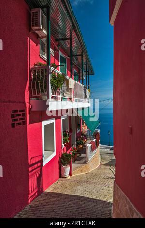 Farbenfrohe Häuser im Dorf Chlomos, Ionisches Meer in der Ferne, Insel Korfu, Griechenland Stockfoto