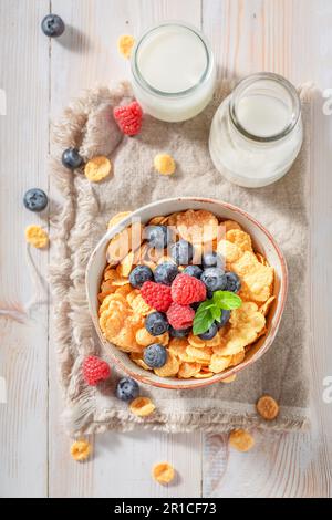 Frische und köstliche Cornflakes aus Himbeeren und Heidelbeeren. Cornflakes mit Beeren als gesundes Frühstück. Stockfoto