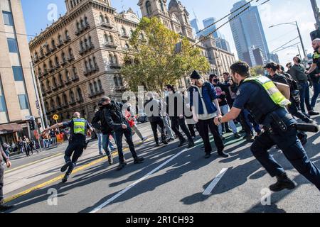 Ein Polizist verfolgt einen anti-faschistischen Demonstranten, der während der Demonstration mit einem Gegenstand nach ihm warf. Ein Tag politischer Spannungen und Zusammenstöße entfaltete sich in Melbourne als rechtsextreme Gruppe einer Neonazi-Gruppe, die eine Anti-Einwanderungs-Kundgebung im staatsparlament veranstaltete, und traf auf heftigen Widerstand von linksgerichteten antifaschistischen Gegenprotestierenden. Die Aufruhr-Polizei wurde eingesetzt, als es zwischen den beiden Gruppen zu Schlägereien kam, mit Pfefferspray und Pferden, um die Menge zu kontrollieren. Protestsignale, die Inklusivität, Vielfalt und soziale Gerechtigkeit fordern, wurden in einer Demonstration der Einheit gegen Hassreden und Diskriminierung hoch gehalten. Die Überschneidung Stockfoto