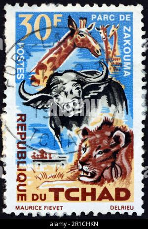 TSCHAD - CA. 1965: Ein im Tschad gedruckter Stempel zeigt Giraffen, Büffel und Löwen, Zakouma Nationalpark, Schutz der Tiere, ca. 1965 Stockfoto