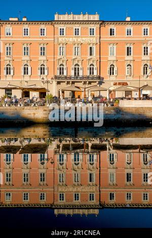 Die Fassade eines palazzo spiegelt sich im Canal Grande, Triest, Italien Stockfoto