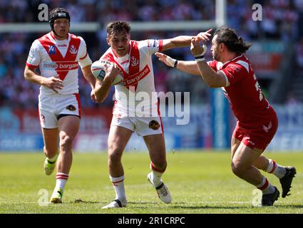 St. Helens' Jonny Lomax (Zentrum), angegriffen von Salford Red Devils' Rhys Williams (rechts) während des Spiels der Betfred Super League im Totally Wicked Stadium, St. Helens. Foto: Samstag, 13. Mai 2023. Stockfoto