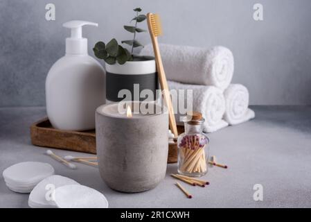 Spa-Komposition mit aromatischer Kerze, Handtüchern und anderem Badezimmerzubehör. Beauty-Spa-Behandlung. Speicherplatz kopieren. Stockfoto