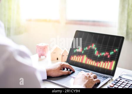 Geschäftsmann, der von zu Hause aus und allein mit der Börse arbeitet und mit einem Laptop Handelsdaten analysiert. Concept man tippt auf die Tastatur, Techn verwenden Stockfoto