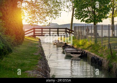 Schöne Brücke mit einem kleinen Kanal in Balatonbolar und Fischerbooten neben dem Balaton. Stockfoto