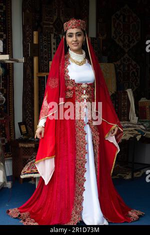 Windsor, Berkshire, Großbritannien. 13. Mai 2023. Eine Dame aus Aserbaidschan zeigt den Gästen, wie sie Wollteppiche von Hand herstellen. Es war ein weiterer geschäftiger Tag bei der Royal Windsor Horse Show auf dem Privatgelände von Windsor Castle. Dieses Jahr feiert die Show den 80. Jahrestag. Die Gäste genossen es, den Pferden beim Wettstreit zuzusehen und einen Einkaufsbummel zu machen. Kredit: Maureen McLean/Alamy Live News Stockfoto