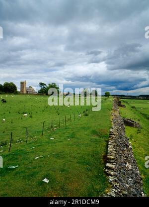 Blick E auf die C4. S-Mauer der römischen Stadt Caerwent (Venta Silurum) und die mittelalterliche Kirche St. Stephen und St. Tathan. Monmouthshire, Wales, Großbritannien. Stockfoto