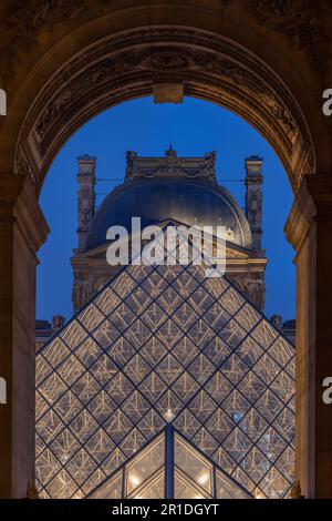 Der Louvre in Paris, Frankreich. Glaspyramiden bei Nacht im berühmten Museum. Stockfoto