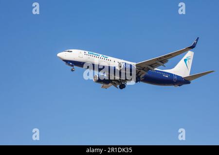 Eine blaue Boeing 737-800 mit Fahrwerk, das sich dem Flughafen nähert. Stockfoto