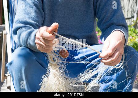 Fischer, die das alte Fischnetz reparieren, traditionelles altes Netz, aus Dalmatien, Kroatien Stockfoto