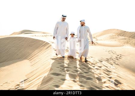 Drei Generationen Familie machen eine Safari in der Wüste von Dubai in weißem Kandura-Outfit. Großvater, Sohn und Enkel verbringen Zeit zusammen im Jahr Stockfoto
