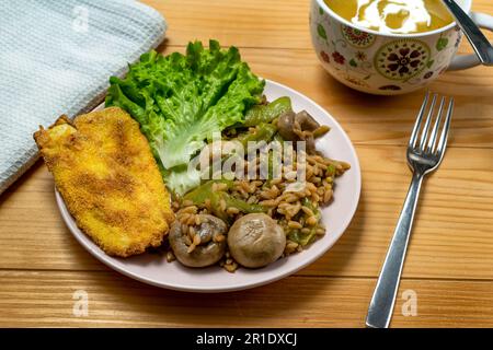 Risoni Pasta - Linsen und Kichererbsen mit Pilzen, knusprig gebratene Zucchini und Salat Stockfoto