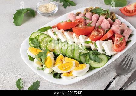 Gesunder cobb-Salat mit Schinken, Fetakäse, Gurke, Tomaten, Oliven und Eiern. Ketogenes Mittagessen Stockfoto