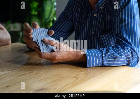 Mann mischt Karten beim Spielen mit Freunden. Stockfoto