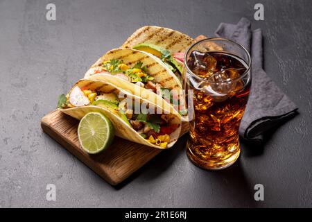 Mexikanische Küche mit Tacos mit Fleisch und gegrilltem Gemüse und ein Glas Cola mit Eis Stockfoto