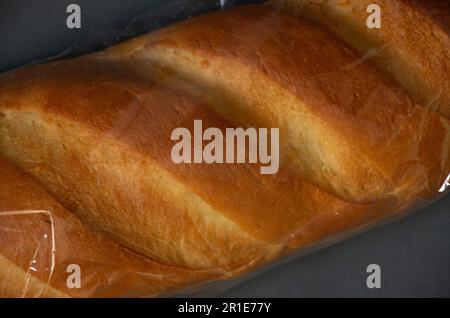 Weißbrotlaib in Verpackung auf dunkler, isolierter Nahaufnahme Stockfoto
