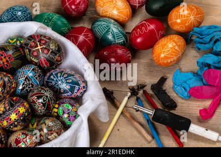 Handbemalte Ostereier und Dekorationsmaterial für die Herstellung von Ostereiern. Ostereier mit heißem Wachs streichen. Stockfoto