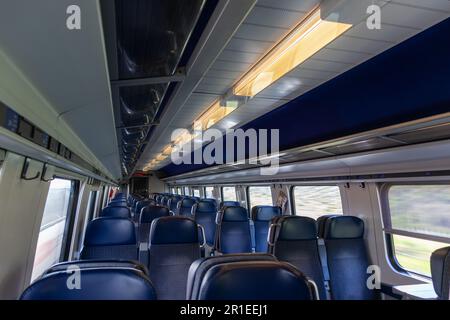 Bern, Schweiz - April 5 2020: In einem leeren Zug am Morgen während der Covid-19-Pandemie in der Schweiz, blaue Sitze in einem Schweizer Zug Stockfoto