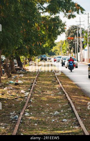 Hausmüll wirft alte, stillgelegte Eisenbahngleise entlang einer Straße in Merida, Mexiko Stockfoto