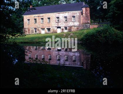 Altes Eisenmühlen-Gebäude an einem See Stockfoto