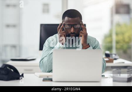 Es ist wirklich einfacher aufzuhören. Ein gutaussehender junger Geschäftsmann, der allein in seinem Büro sitzt und gestresst ist, während er sein Notebook benutzt. Stockfoto