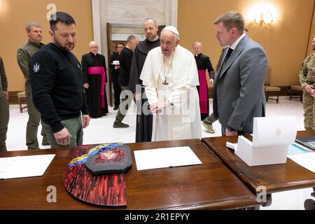 Rom, Italien. 13. Mai 2023. Der ukrainische Präsident Volodymyr Zelenskyy, Left, präsentiert das Gemälde "Loss, 2022-58" von Oleksiy Revika an Papst Franziskus, Zentrum, während eines Besuchs im Vatikan am 13. Mai 2023 in Rom, Italien. Das Gemälde wurde mit einer kugelsicheren Westenteller erschaffen, die von einem ukrainischen Soldaten getragen und mit einem Bild der Madonna bemalt wurde. Kredit: Pool Photo/Pressestelle Des Ukrainischen Präsidenten/Alamy Live News Stockfoto