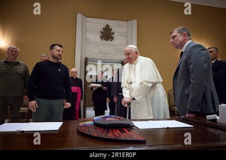 Rom, Italien. 13. Mai 2023. Der ukrainische Präsident Volodymyr Zelenskyy, links, präsentiert das Gemälde "Loss, 2022-58" von Oleksiy Revika an Papst Franziskus, rechts, während eines Besuchs im Vatikan am 13. Mai 2023 in Rom, Italien. Das Gemälde wurde mit einer kugelsicheren Westenteller erschaffen, die von einem ukrainischen Soldaten getragen und mit einem Bild der Madonna bemalt wurde. Kredit: Pool Photo/Pressestelle Des Ukrainischen Präsidenten/Alamy Live News Stockfoto
