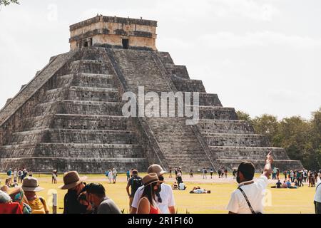 Touristen stehen vor El Castillo, dem Haupttempel an der archäologischen Stätte Chichén Itzá, Mexiko Stockfoto