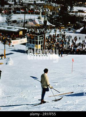 1960 Olympische Winterspiele im Squaw Valley, Kalifornien: Einbeinige Skifahrer beobachten die Skifahrer auf dem Slalom-Golfplatz Stockfoto