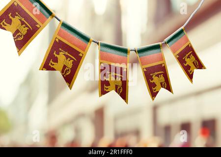 Eine Girlande Sri Lankas Nationalflaggen auf abstraktem, verschwommenem Hintergrund. Stockfoto