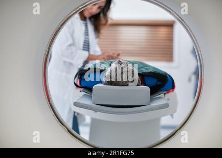 Arzt, CT-Scan und Frau Komfort Patient im Krankenhaus vor Scan im Gerät. MRT, Händchenhalten und medizinisches Fachpersonal mit Seniorin Stockfoto