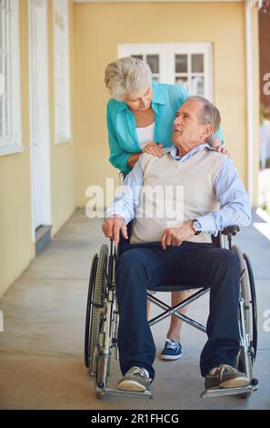 Sprechende, alte Frau oder Seniorenrollstuhl im Ruhestand- oder Pflegeheim, die dem Ehemann bei der Unterstützung hilft. Wellness, Pärchen oder ältere Ehefrau, die einen schubst Stockfoto
