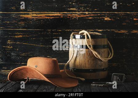 Cowboyhut, Lasso und Hufeisen auf Holzhintergrund Stockfoto