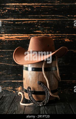 Cowboyhut, Lasso und Hufeisen auf Holzhintergrund Stockfoto