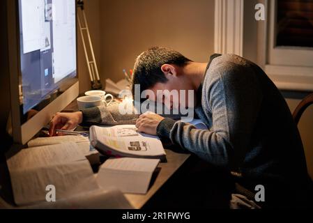 Junge Studentin, Bücher, die neben der Leinwand schlafen, bis spät in die Nacht lernen oder sich auf dem Tisch ausruhen und für die Prüfung lesen. Müde, Nachforschungen und Stockfoto