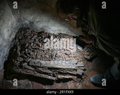 Boitzenburg, Deutschland. 22. April 2023. Archäologe und Kunsthistoriker Andreas Ströbl untersucht die dünnen Überreste eines Kindersargs in einer Gruft der edlen Familie von Arnim in der Pfarrkirche St. Mary auf dem Berg. (Zu dpa-KORR Rescue für die historische Boitzenburger Kirchengruft) Kredit: Patrick Pleul/dpa/Alamy Live News Stockfoto