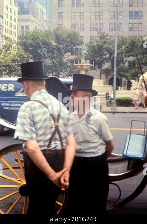 Hansom Taxifahrer, die sich in der Nähe ihrer Taxis in New York unterhalten. Ende 1960er Stockfoto