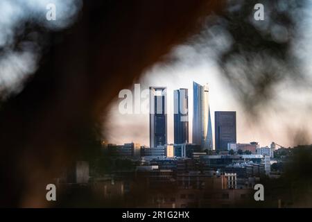 Die Hauptstadt von Madrid hat vier Türme, die versteckt und zwischen Baumblättern in der Natur mit Kopierraum zu finden sind Stockfoto