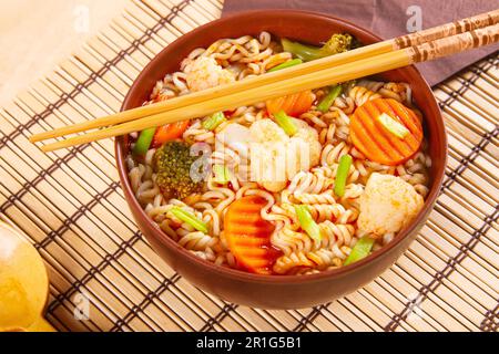 Asiatisches Speisenkonzept. Nudeln und Gemüse auf Bambusmatte Stockfoto