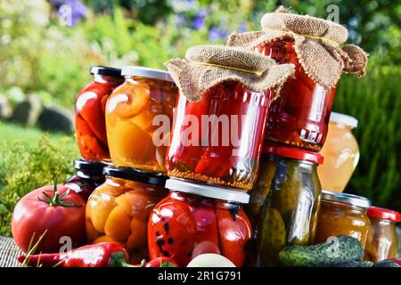 Eingelegte Gemüse- und Obstgläser im Garten. Mariniertes Essen Stockfoto