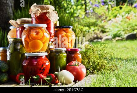 Eingelegte Gemüse- und Obstgläser im Garten. Mariniertes Essen Stockfoto