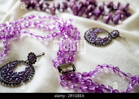 Amethyst-Halskette und Ohrringe auf weißem Hintergrund. Stockfoto