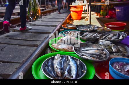 Verkauf von Speisen auf der Maeklong Railway Markt in Thailand Stockfoto