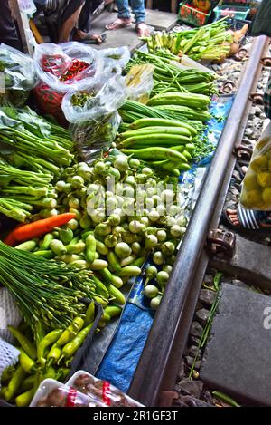 Verkauf von Speisen auf der Maeklong Railway Markt in Thailand Stockfoto