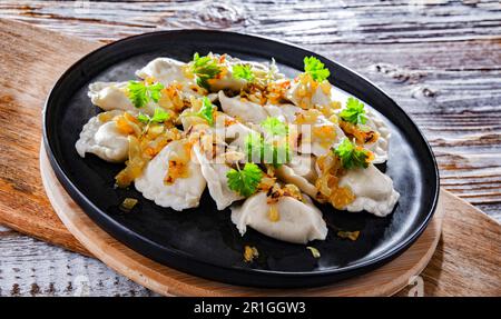 Komposition mit einem Teller klassischer Pierogien mit Zwiebeln Stockfoto