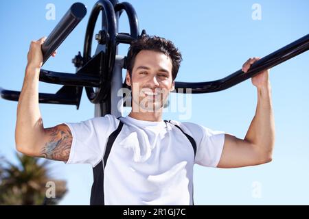 Glücklicher Mann, Fitness und Porträt mit Geräten im Park Gym für Training, Training oder Training in der Natur. Fit, aktiv und kräftig männlich beim Training Stockfoto