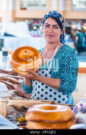 SAMARKAND, Usbekistan - Mai 10, 2019: Frau Verkauf von Brot an siab Basar im Zentrum von Samarkand, Usbekistan Stockfoto