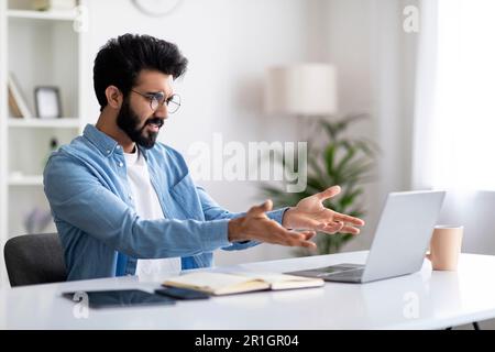 Arbeitsbelastung. Wütender Junger Indischer Freiberufler Hat Probleme Mit Dem Laptop Stockfoto