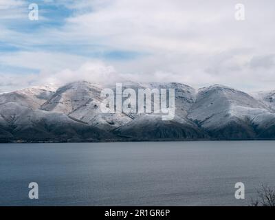 Sewansee, Armenien, mit der Bergkette des Kleinkaukasus im Hintergrund an einem bewölkten Wintermorgen Stockfoto